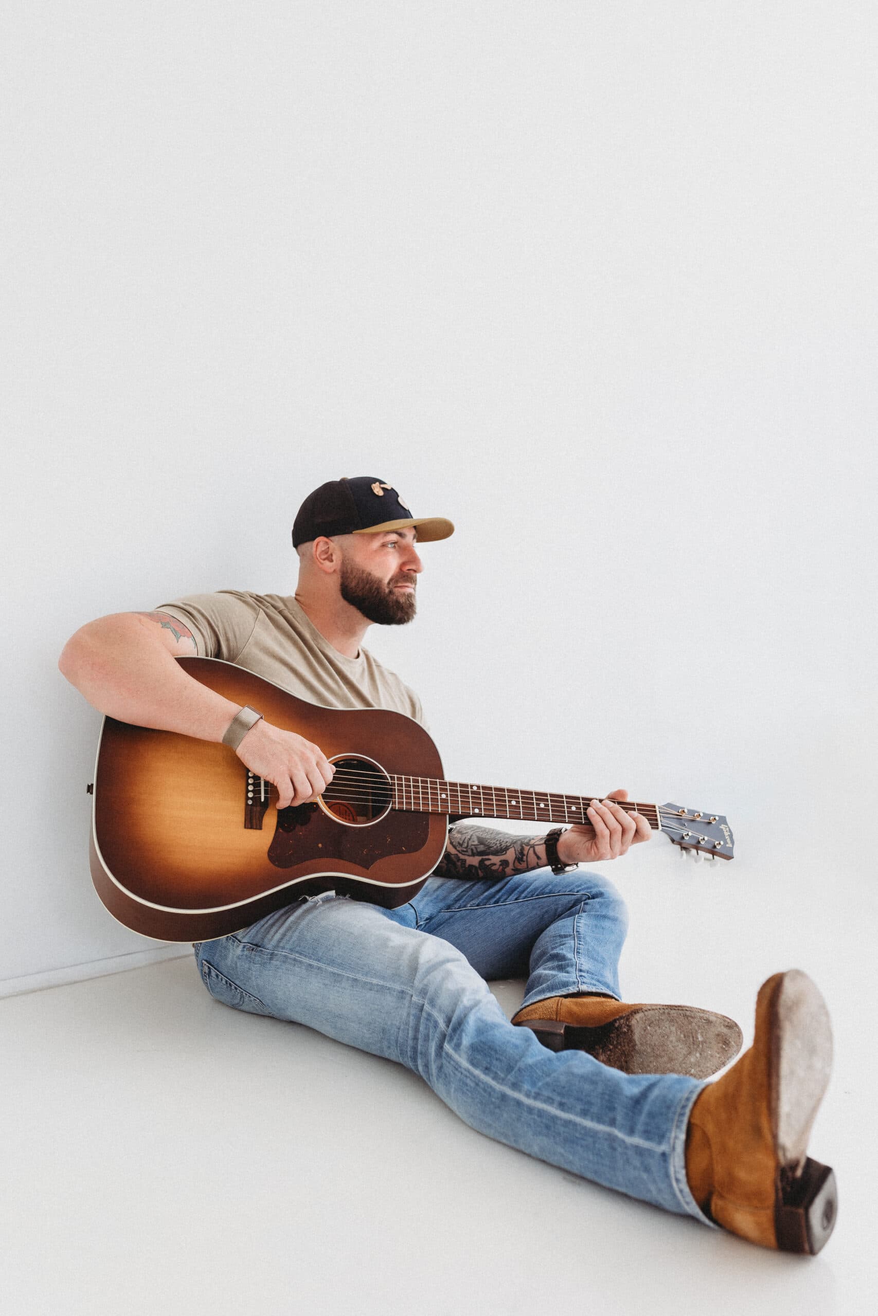 Ralph Curtis seated on the floor with his guitar